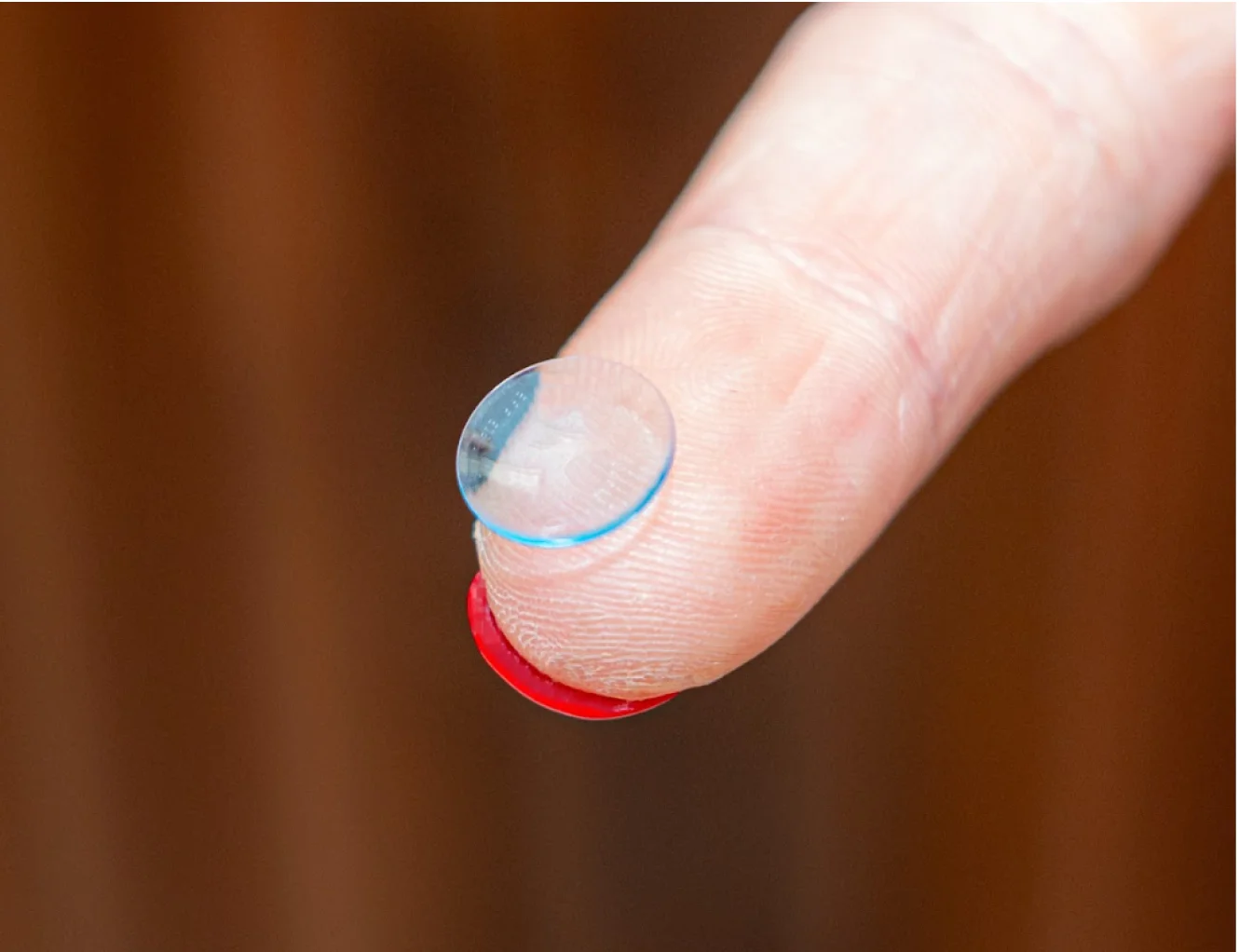 Custom scleral contact lens balanced on a fingertip